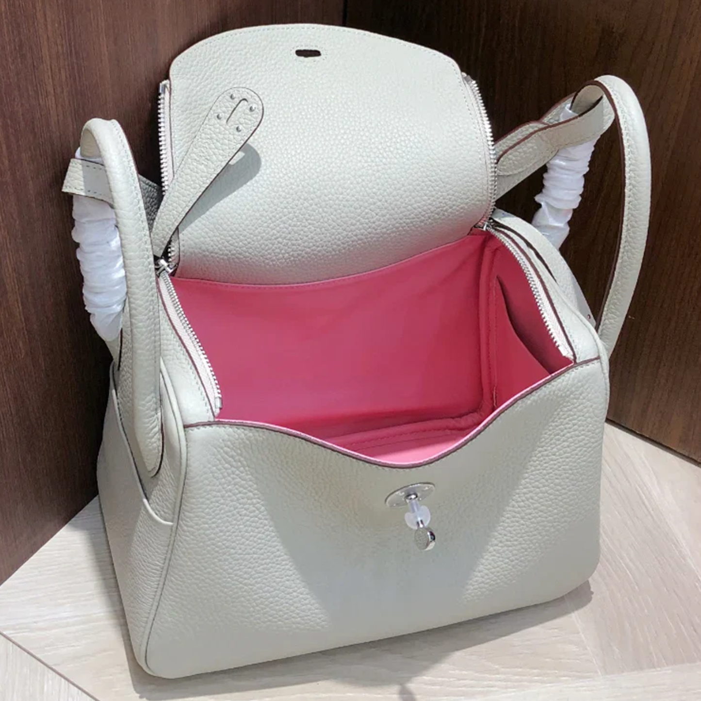 Pale Milky Off White Pebble Grain Rounded Compact Shoulder Bag With Polished Silvery Turn Lock Hardware And Blush Toned Inner Lining