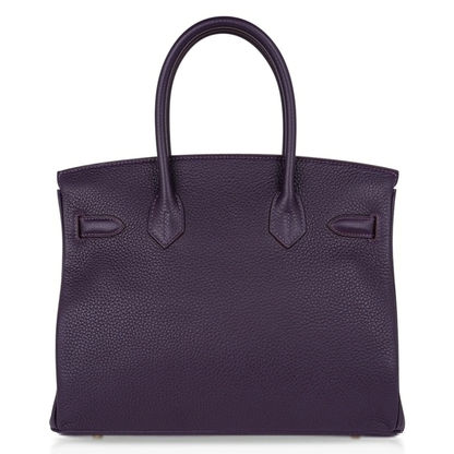 Deep Ripe Grape Textured Medium Structured Trapezoid Hand Tote With Luminous Warm Golden Twist Lock Hardware And Matching Suspended Engraved Metal Padlock Charm
